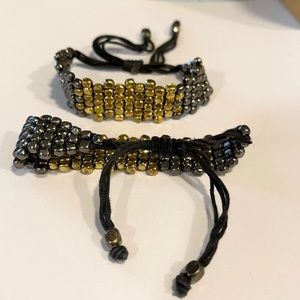 One pair of gold and gunmetal adjustable bracelets